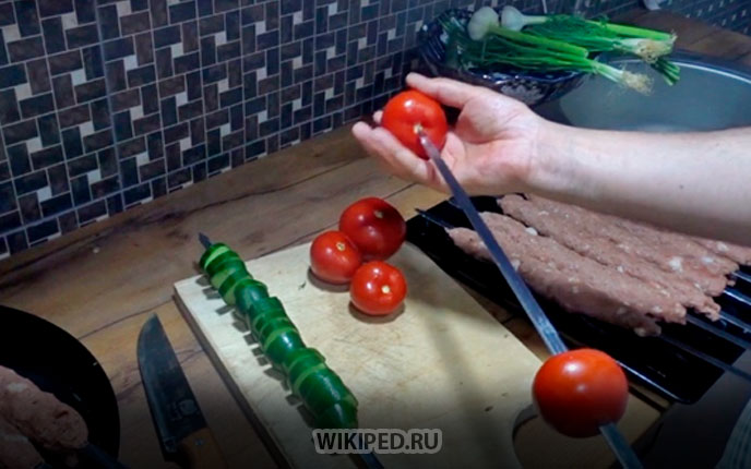 На отдельный шампур насадите целые помидоры и нарезанный кольцами огурец.